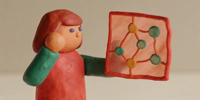 A clay figure holding a translucent sheet with interconnected nodes, representing network analysis transparency